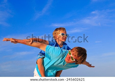 Similar – Image, Stock Photo Father and son playing superhero on the beach at the day time. People having fun outdoors. Concept of summer vacation and friendly family.