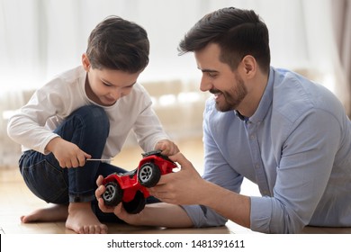 Father And Little Son Spend Time Together At Modern Home Dad Helps To Kid With Repair Works, Boy Hold Screwdriver Fix Broken Truck Lorry Red Car, Skills Transmitted From One Generation To Next Concept