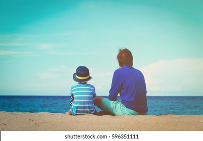 Father And Little Son Talking On Beach