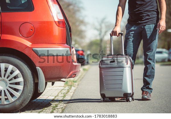 Father loading a luggage\
to the car, preparing for a vacation or holiday abroad,\
transportation concept