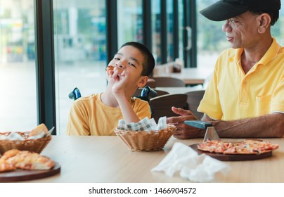 Father looked at his disabled son on the wheelchair eating food with his beloved eyes, Special children's lifestyle, Life in the education age of special need children, Happy disability kid concept.