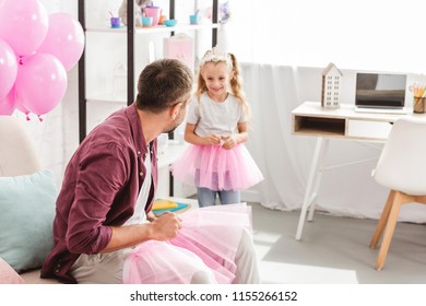 Father Looking To Daughter In Pink Tutu Skirt