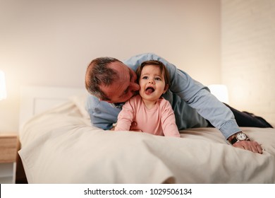 Father Lying On Bed , Kissing His Baby Girl