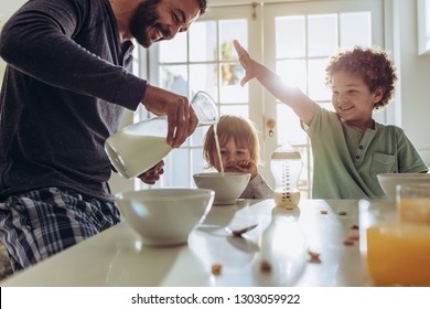 Father Making Breakfast For His Kids At Home. Man Having Fun Preparing Breakfast At Home With His Kids.