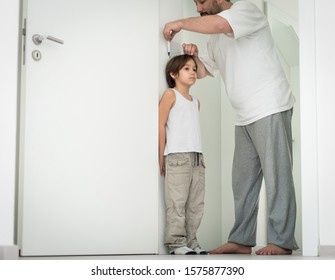 Father measuring the height of his son - Powered by Shutterstock