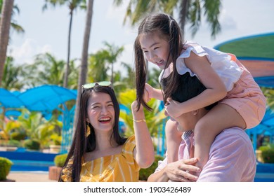 Father And Mother And Daughter Play At The Amusement Park. Family In Theme Park.