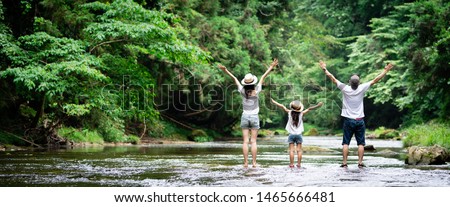 Father and mother and daughter playing in the river