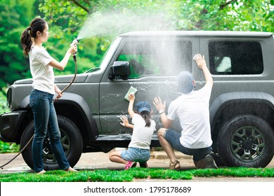 Father, Mother And Daughter Wash The Car