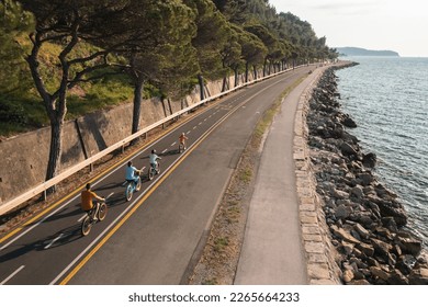 Father, mother, and their two children riding bicycles, enjoying a beautiful summer day, drone shot. Active family vacation concept. - Powered by Shutterstock