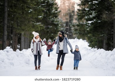 Father and mother with two small children in winter nature, walking in the snow. - Powered by Shutterstock