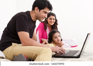 Father And Mother Using Laptop With Daughter, Muslim Family Of Three.