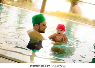 Father And Newborn Baby Son Floating At The Swimming Pool Learn To Stay Afloat