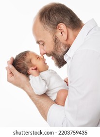 Father With Newborn. Happy Dad Kissing Baby. Smiling Man Holding One Month Little Child In Hands Over White. Parent Playing With Infant. Kids Health Care And Parenting.