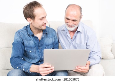 Father And Older Son Looking At Laptop