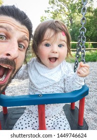 father and one year old daughter shooting a selfie at the playground