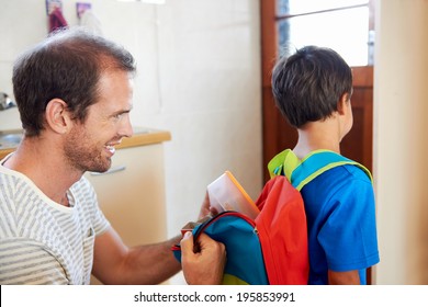 Father Packing School Lunch Into Son Backpack Before He Goes To Learn