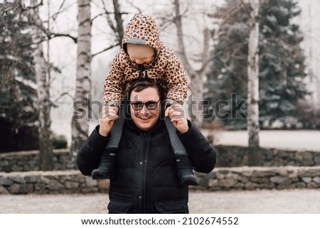 Father playing with child outdoors. Happy parenting, family bond. Toddler preschool girl daughter with father on his shoulders