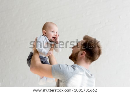 father playing with little son at home 