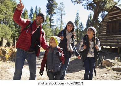 Father Pointing Something Out To His Family During A Hike