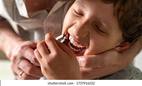 Father Pulled Out His Son's Baby Tooth With A Pliers Construction Tool. Concepts Of Self-treatment At Home. The Child Lost A Tooth.