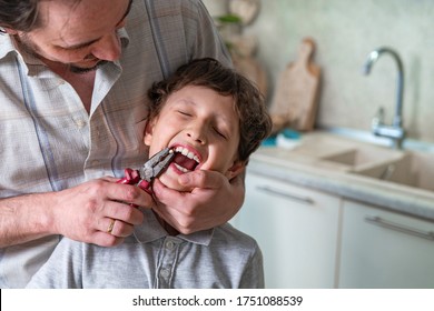 Father Pulled Out His Son's Baby Tooth With A Pliers Construction Tool. Concepts Of Self-treatment At Home. The Child Lost A Tooth.