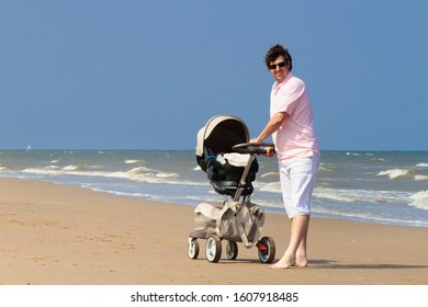 Father Pushing Baby In Stroller On Tropical Beach. Car Seat Pram System For Newborn Child. Dad And Infant Daughter Walking On Sea Shore On Summer Vacation. Kids Safety. Travel With Young Children.