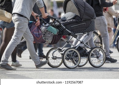 Father Pushing Stroller On The Street