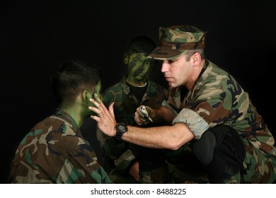 Father Puting Camo Paint On Children's Faces Over Black.