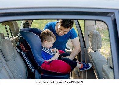 Father Putting Baby In Safety Car Seat Dad And Child Together Family Road Trip Vacations Lifestyle Infant Kid Transportation Rear-facing.