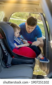 Father Putting Baby In Safety Car Seat Dad And Child Together Family Road Trip Vacations Lifestyle Infant Kid Transportation Rear-facing