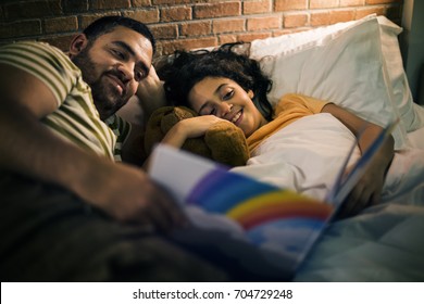 Father Reading Bed Time Story With Daughter