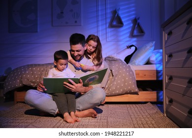 Father reading bedtime story to his children at home
