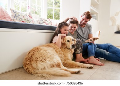 Father Reading Book With Son And Daughter And Pet Dog At Home - Powered by Shutterstock