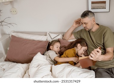 A father reads a bedtime story to his two daughters who are already asleep in bed. He is gently stroking the hair of the daughter closest to him, while the other daughter is resting peacefully.  - Powered by Shutterstock