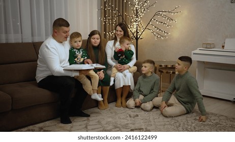 A father reads the bible while sitting on the sofa at home with his extended family - Powered by Shutterstock