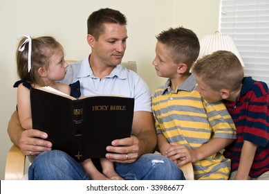 A father reads to his three young children from the Holy Bible.