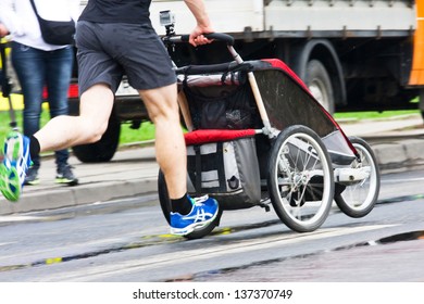 Father run with baby stroller in marathon