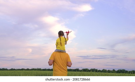 father runs with small child his arms, kid dreams being an airplane pilot, happy family, cheerful childhood girl with dad, joyful weekend trip with baby, father day, beloved parent entertain daughter