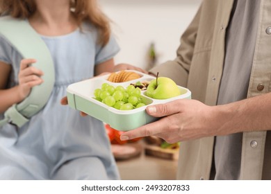 Father with school lunchbox for his little daughter in kitchen, closeup - Powered by Shutterstock