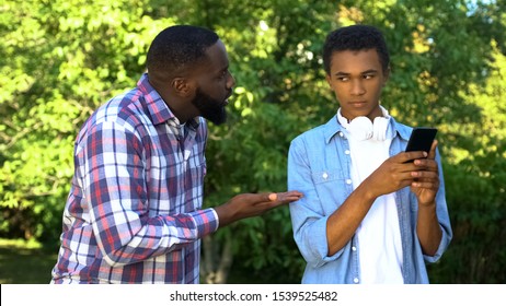 Father Scolding Male Teen Son Playing Smartphone Game Ignoring Parent Upbringing