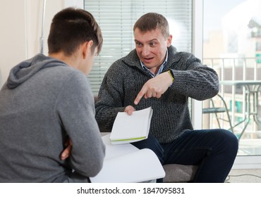Father Scolding Son For Poor School Assignment. High Quality Photo
