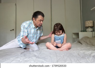 Father Scolds The Child With A Smart Phone, Girl Child Is Immersed In The Phone, The Child Ignores The Parent