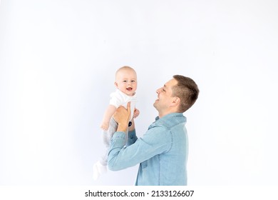 A Father With A Small Child Son On A White Isolated Empty Background In A Photo Studio Playing, Hugging. Happy Fatherhood Or Family