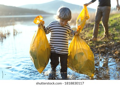 Father With Small Son Collecting Rubbish Outdoors In Nature, Plogging Concept.