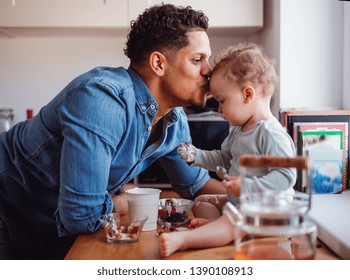 A Father And A Small Toddler Son Eating Fruit And Yoghurt Indoors At Home.