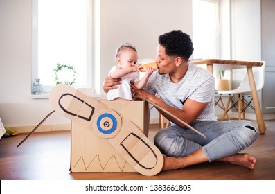 Father And Small Toddler Son Indoors At Home, Playing.