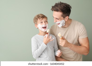 Father with son applying shaving foam onto their faces against color background - Powered by Shutterstock