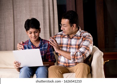 Father and son astonished on receiving good news using laptop