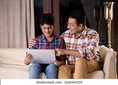 Father and son astonished on receiving good news using laptop