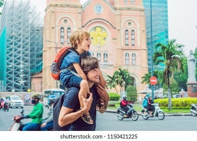 Father and son in the background Notre dame de Saigon Cathedral, build in 1883 in Ho Chi Minh city, Vietnam